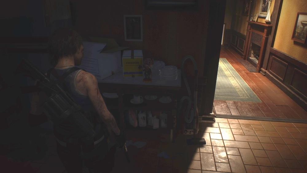 This Charlie Doll is secreted in the shadows right when you enter the house at the end of the alley behind Gun Shop Kendo.